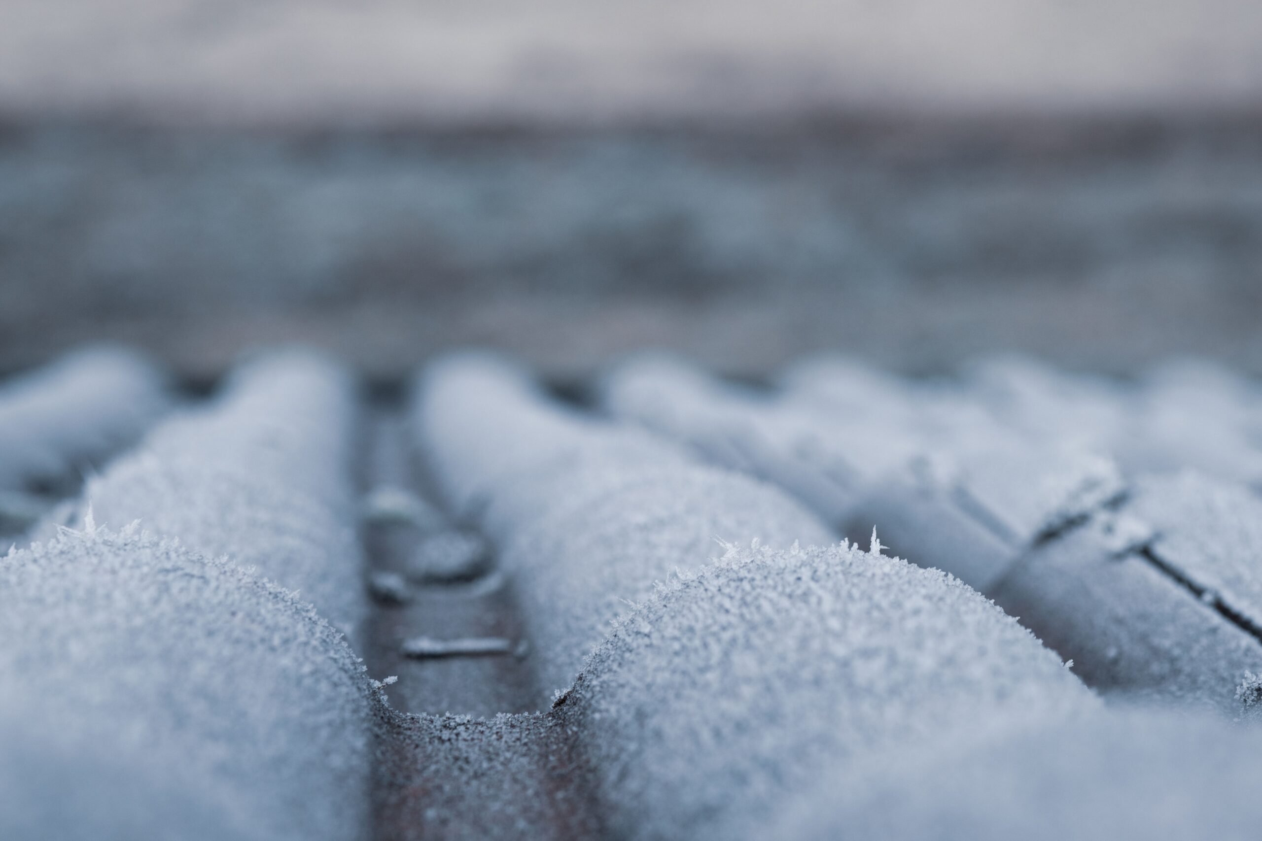 Newly installed asphalt shingle roof on a two-story home with a light dusting of snow along the eaves.